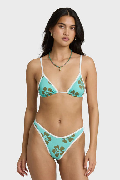 Woman wearing a turquoise bikini with floral patterns on a white background