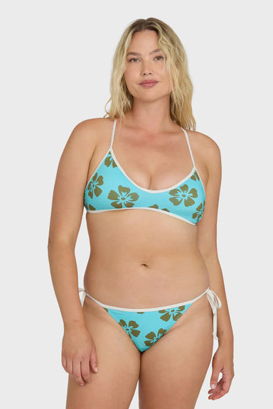 Woman wearing a blue bikini with floral pattern on a white background