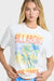 Woman wearing a Billabong t-shirt with palm tree graphic and blue bikini bottoms against a white background