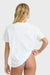 Woman wearing a white tee and blue bikini bottoms against a white background