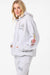 Person wearing a light gray hoodie with floral designs on a white background
