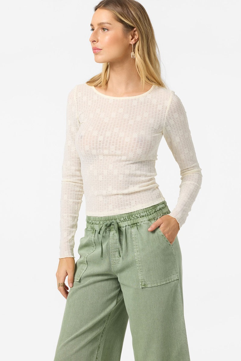 Woman wearing a white sweater and green pants on a white background