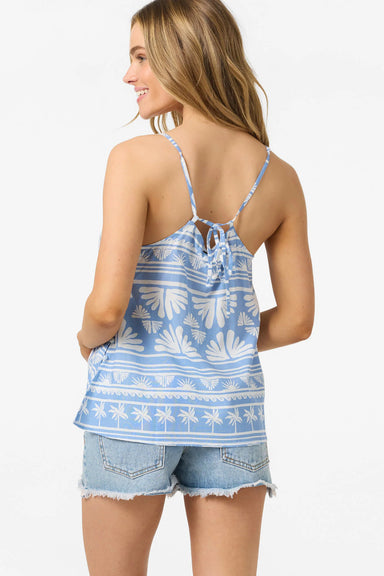 Woman wearing a blue and white patterned tank top and denim shorts on a white background