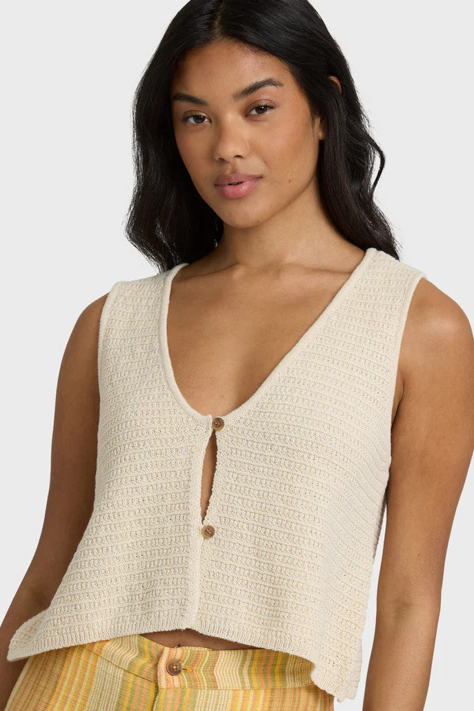 Close up of woman wearing a beige knit tank