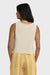 Back view of a woman wearing a beige knit tank with yellow striped pants on a white background