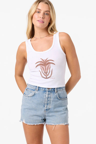 Woman wearing a white tank top with a palm tree design and denim shorts on a white background