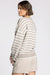 Woman wearing a striped sweater and beige shorts on a white background