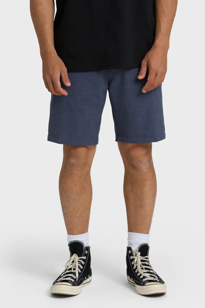 Person wearing blue shorts and black high-top sneakers on a white background