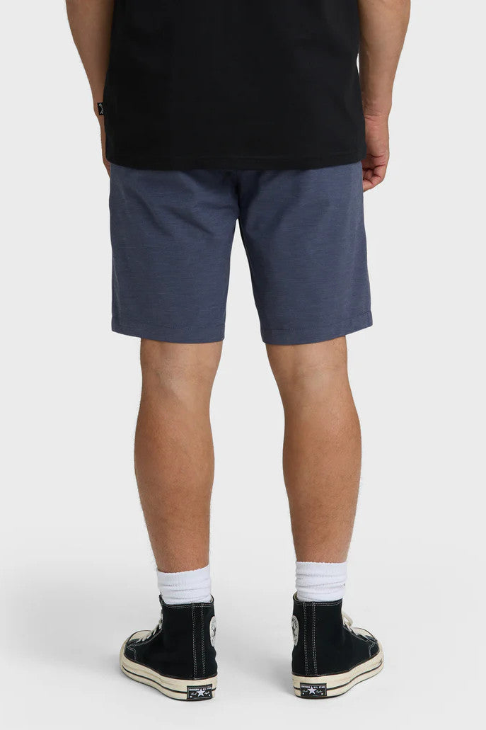 Person wearing navy shorts and black shoes on a white background