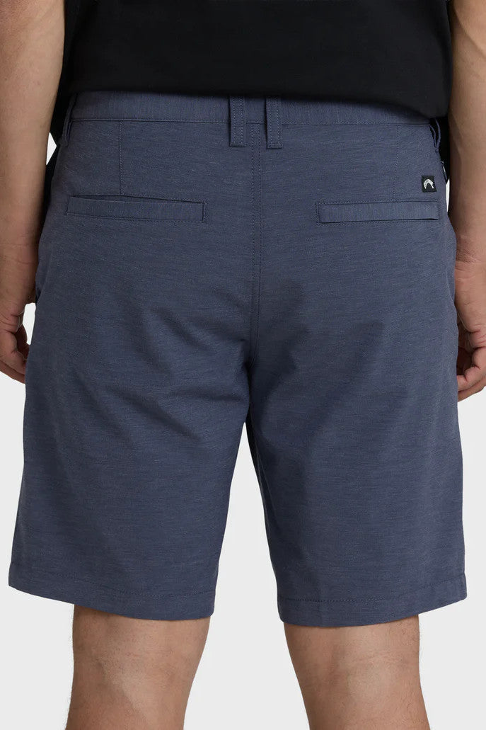 Navy blue shorts worn by a person on a light gray background