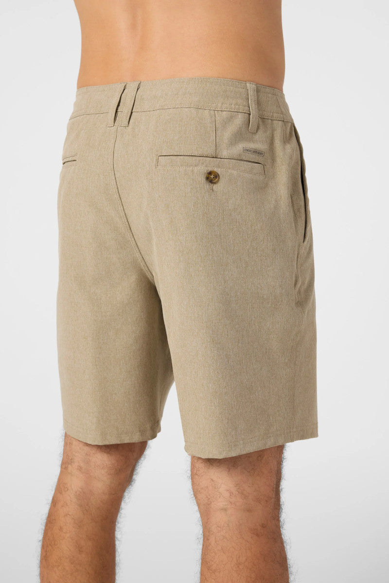 Beige shorts worn by a person on a white background