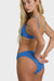 Woman wearing a blue bikini against a white background