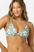 Woman wearing a green floral bikini top against a white background