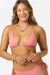 Woman wearing a pink bikini set on a white background