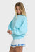 Woman wearing a light blue sweatshirt and white shorts with blue text on a white background