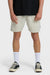 Man wearing beige shorts, black shirt, white socks, and black sneakers on a white background