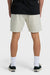 Man wearing beige shorts, black shirt, white socks, and black sneakers on a white background