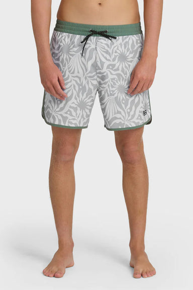 Man wearing gray swim trunks with a leaf pattern and contrasting green elastic waistband with drawstring on a white background