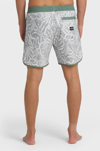 Back view of a man wearing gray swim trunks with a leaf pattern and contrasting green elastic waistband with drawstring on a white background
