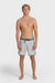 Man wearing gray swim trunks with a leaf pattern and contrasting green elastic waistband with drawstring on a white background