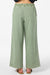 Green wide-leg pants worn by a person on a white background