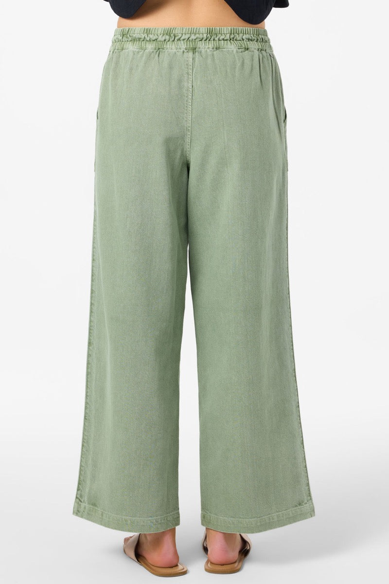 Green wide-leg pants worn by a person on a white background