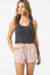 Woman wearing a gray tank top and pink shorts on a white background