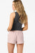 Woman wearing a black sleeveless top and pink shorts on a white background