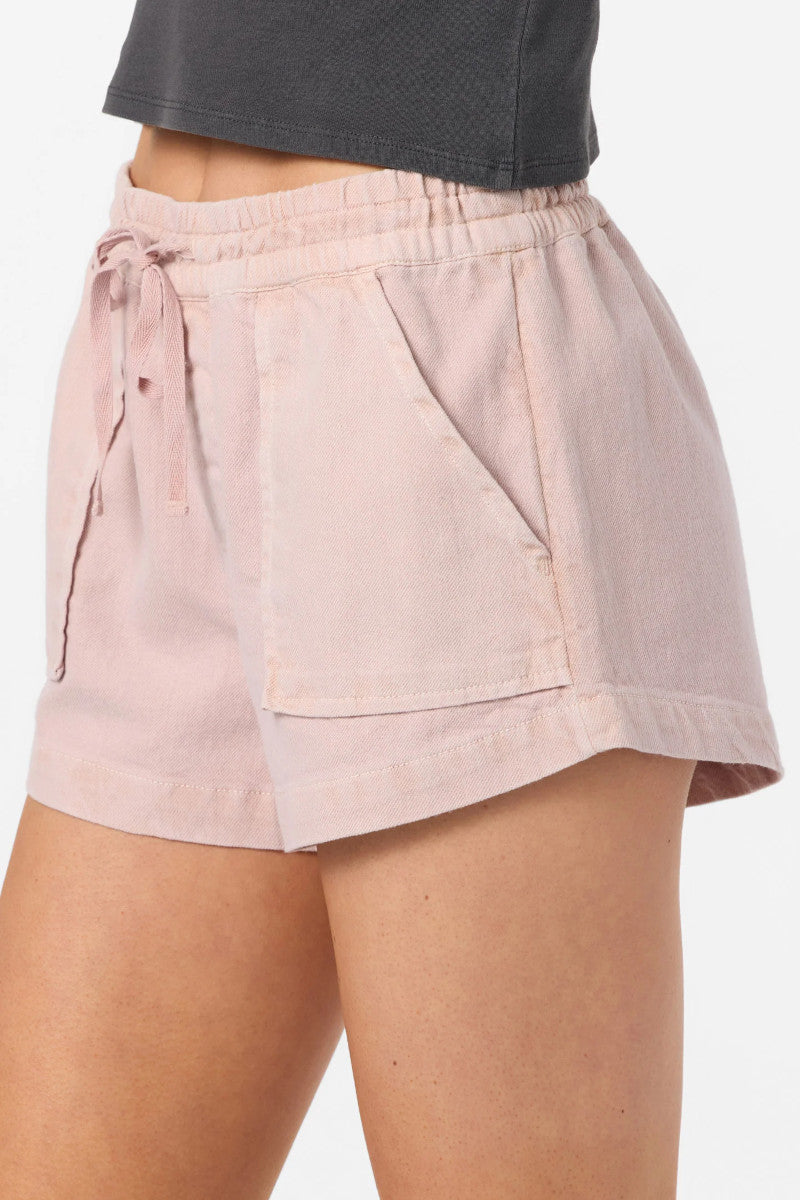Pink shorts worn by a person on a white background
