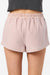 Pink shorts worn by a person on a white background
