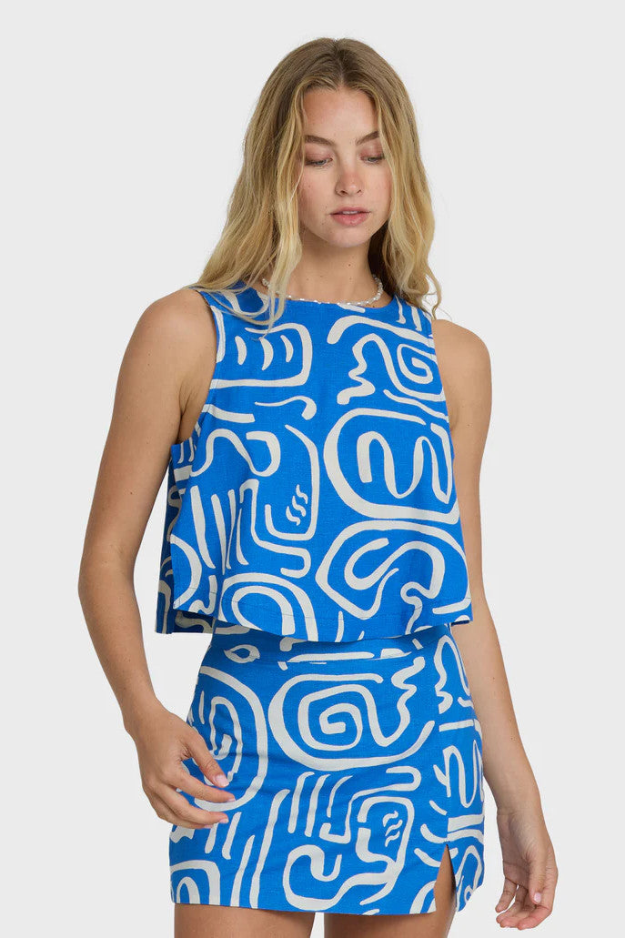 Woman wearing a blue and white patterned dress on a white background