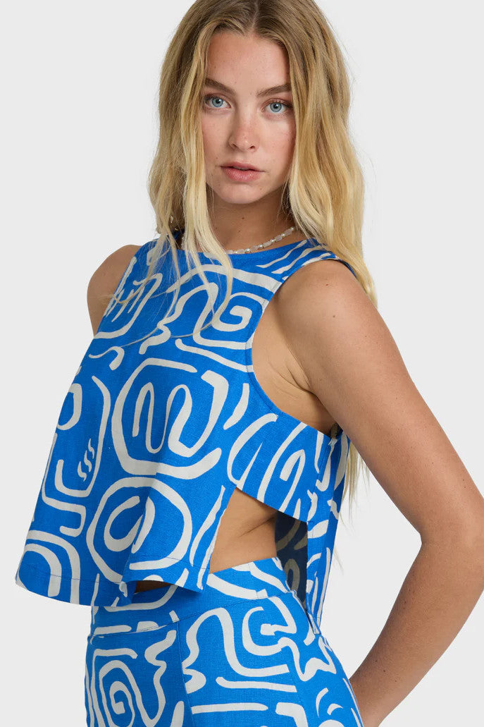 Woman wearing a blue and white patterned sleeveless top on a white background