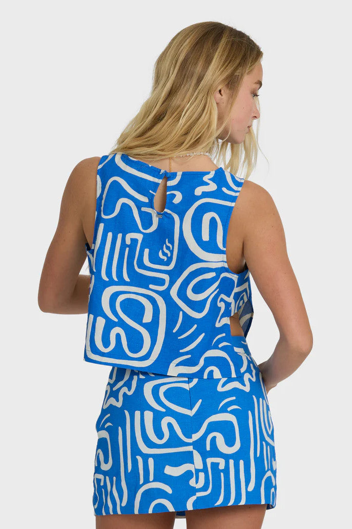 Woman wearing a blue and white patterned dress on a plain background