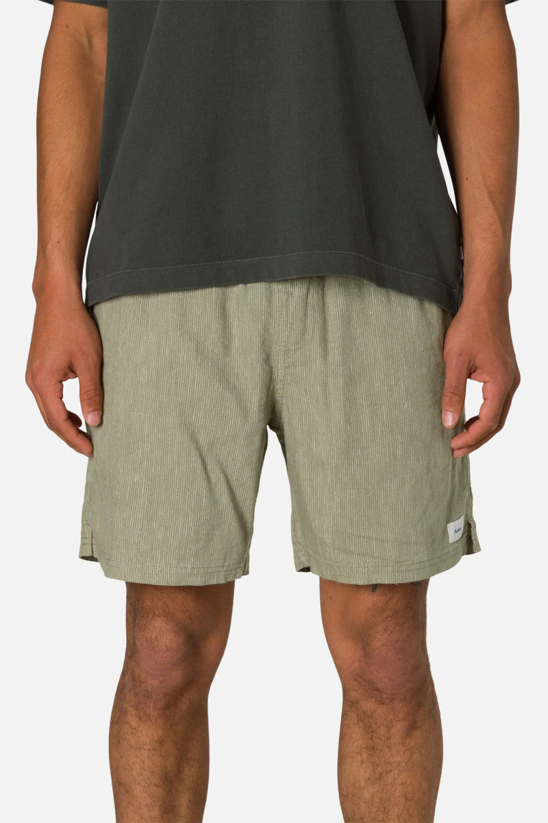 Person wearing green shorts and a black shirt on a white background