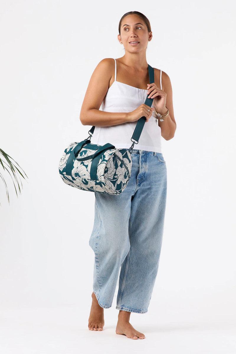 Woman holding a floral-patterned bag against a white background