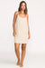 Woman wearing a beige slip dress on a white background
