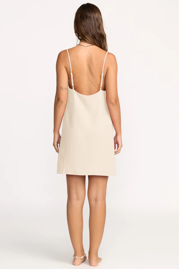 Woman wearing a beige slip dress on a white background