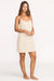 Woman wearing a beige slip dress on a white background