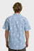 Back view of a man wearing a light blue button-up shirt with white palm tree pattern on a white background