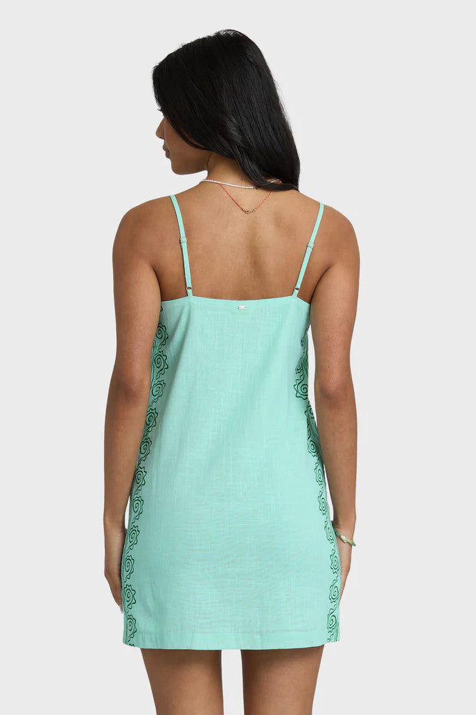 Woman wearing a light blue dress with floral embroidery on a white background