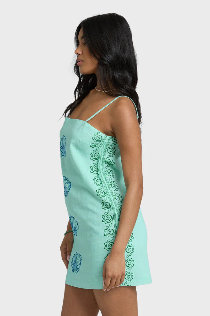 Woman wearing a light blue dress with floral patterns on a white background