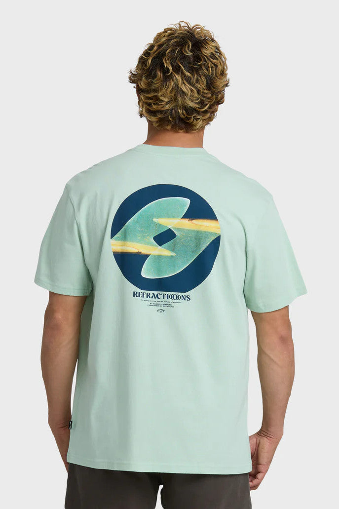 Man wearing a light green t-shirt with a graphic design on the back, standing against a white background.