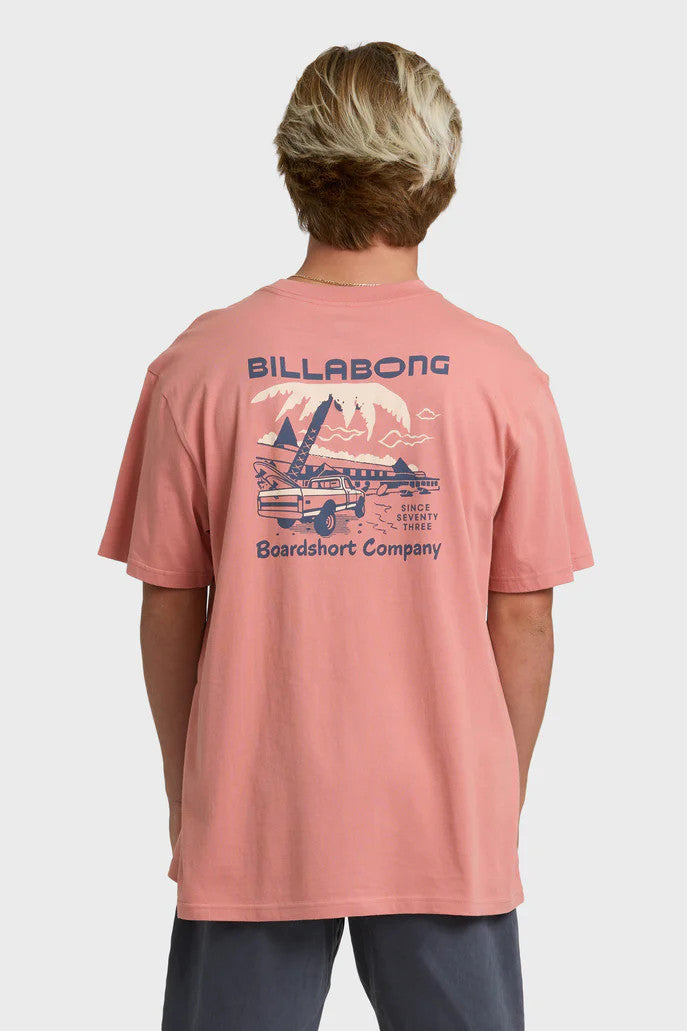 Person wearing a pink Billabong t-shirt with a graphic design on the back against a white background