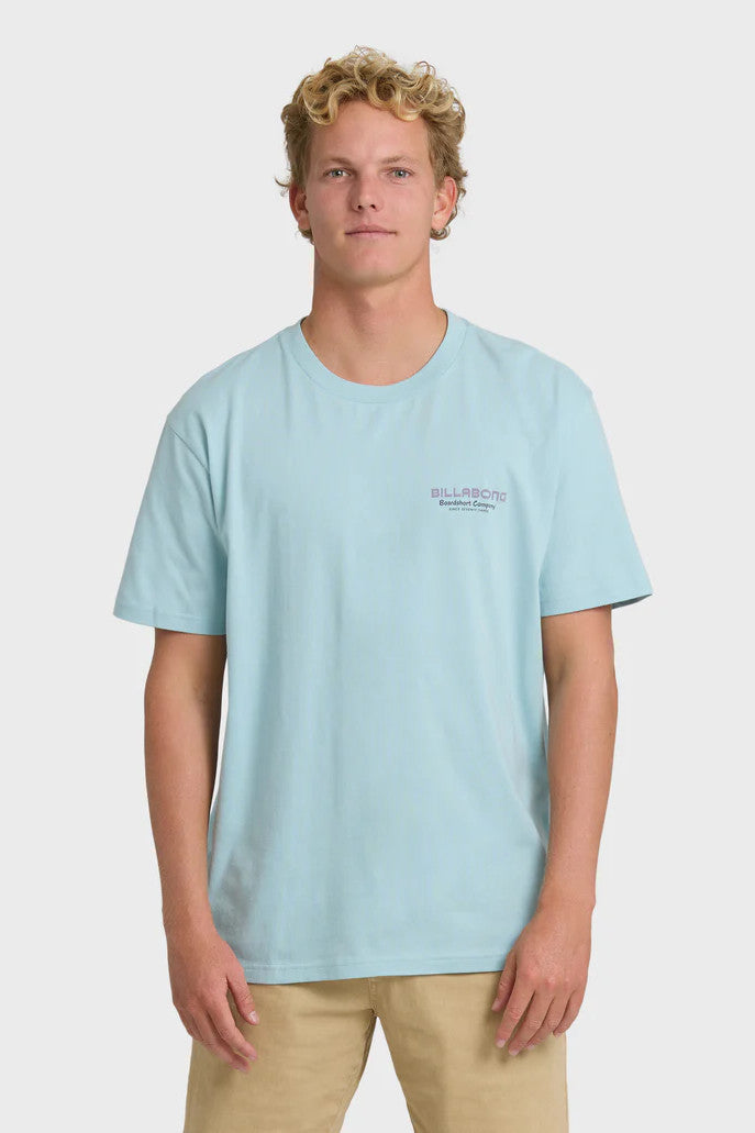 Man wearing a light blue t-shirt with a logo on a white background