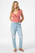 Woman wearing a pink top and light blue jeans on a white background