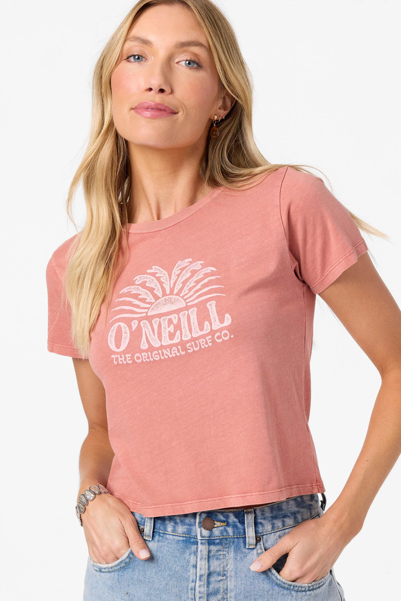 Woman wearing a pink O'Neill t-shirt with a white graphic design on a plain background
