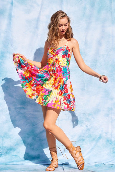 Woman in a colorful floral dress against a light blue background