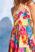 Colorful tropical dress with floral pattern against a light blue background.