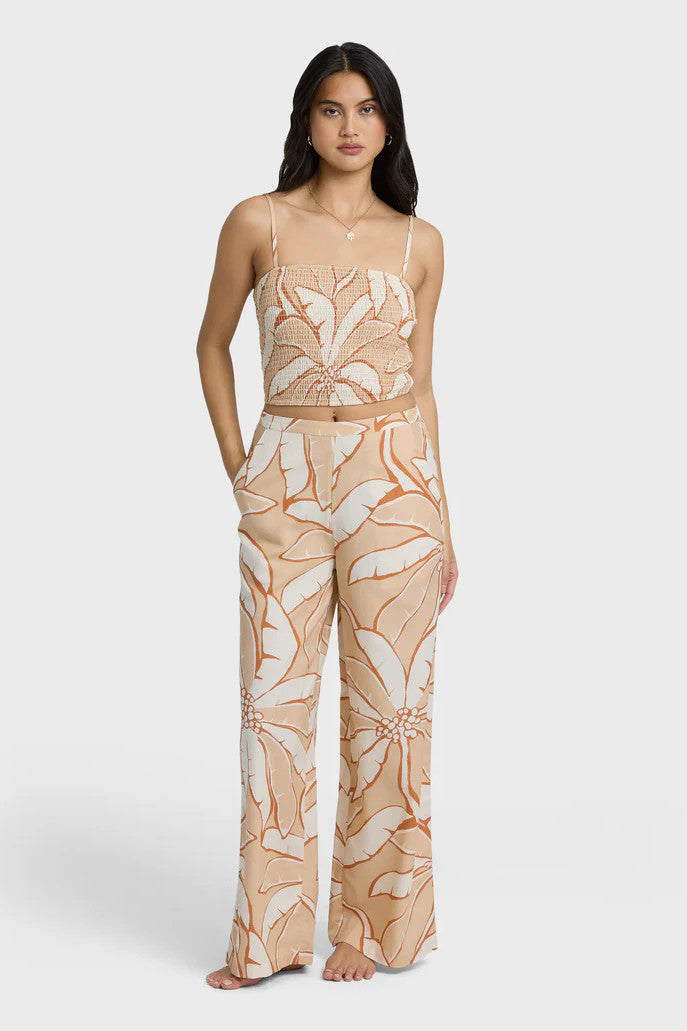 Woman wearing a tropical print two-piece set on a white background