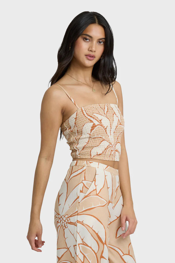 Woman wearing a tropical print dress on a white background